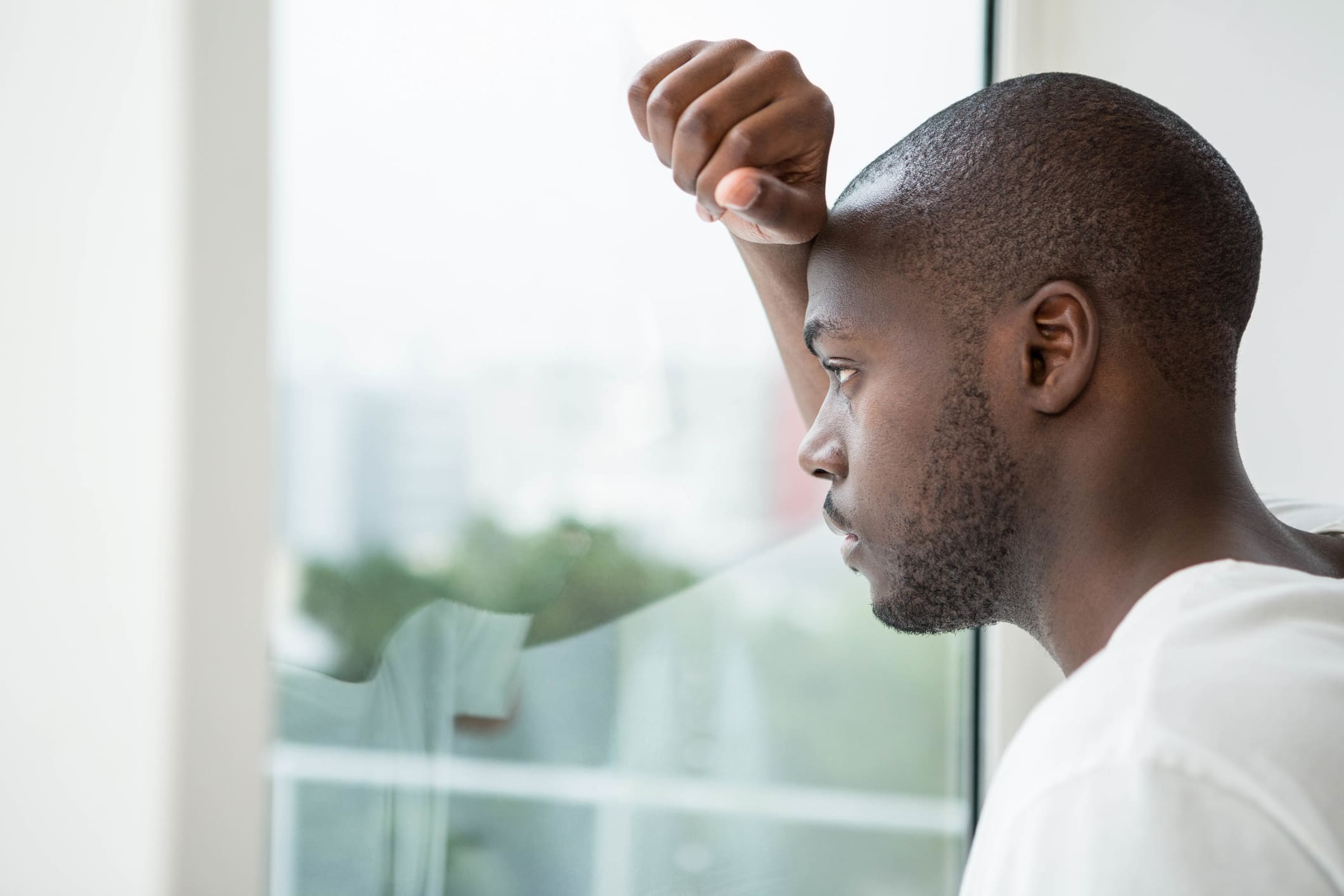 Thoughtful man looking out the window in bedroom at home Visual Journaling